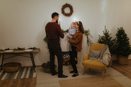 Merry Christmas and Happy Holidays! Pretty family spend good time together in front of the fireplace.の写真素材