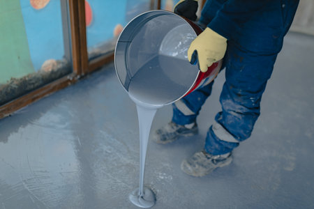 The worker applies gray epoxy resin to the new floorの写真素材