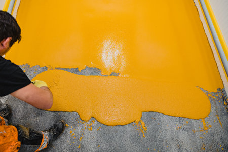 Worker applying epoxy and polyurethane flooring system.These easy-to-clean products also have non-slip features.の写真素材
