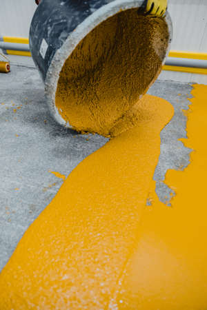 Worker applying epoxy and polyurethane flooring system.These easy-to-clean products also have...