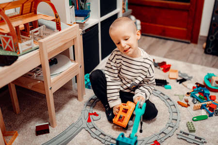 Happy preschool child playing with toy bricks on the carpet floor. childhood education construction conceptの写真素材