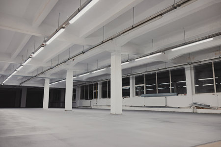 <p>Interior of an empty car park with white walls and concrete floor</p>の写真素材