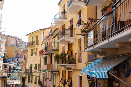 impressive view of beautifully colored buildings, with elegant balconies and ornamental plants in the picturesque town of Manarola, located in the 5 Terre region of Italy. The composition perfectly captures traditional Italian architecture, offering a sense of warmth and comfort.の写真素材