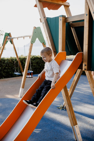 Cute little boy playing on a children's playground on a sunny dayの写真素材