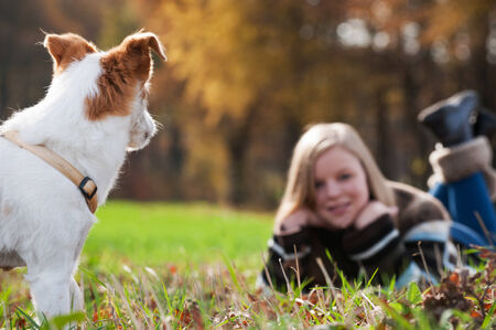 Girl with dog in autumn landscapeの写真素材