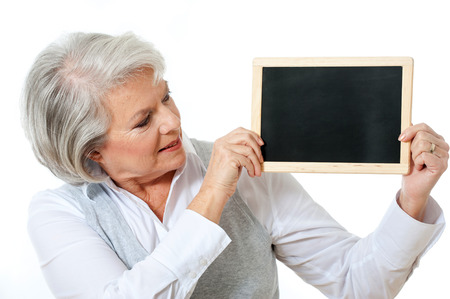 Elderly woman holding chalk board in her handsの写真素材