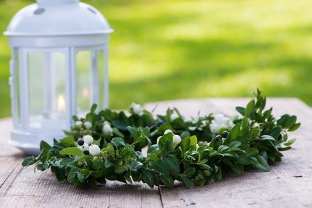 Green wreath with berries on a wooden backgroundの写真素材