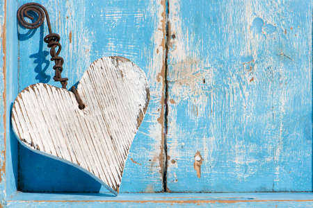 White wooden heart on blue wooden backgroundの写真素材
