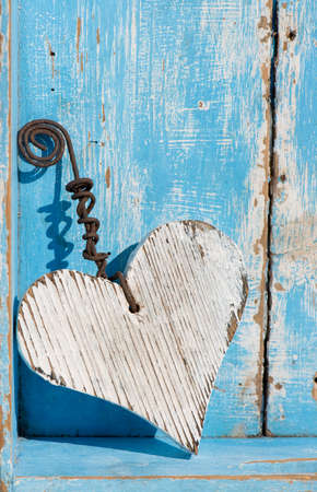 White wooden heart on blue wooden backgroundの写真素材