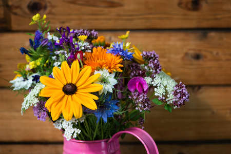 Wild flower bouquet in a watering canの写真素材