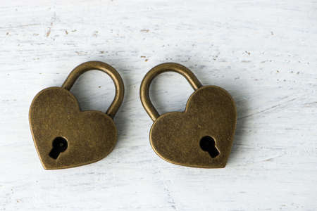 Heart locks on white wooden backgroundの写真素材