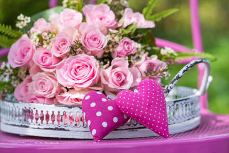 Pink roses flower bouquet on a romantic garden chairの写真素材