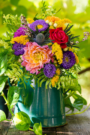 Autumn flower bouquet with dahlia in an enamel teapotの写真素材