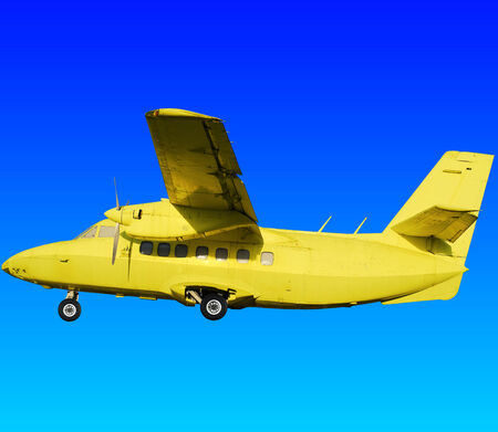 Yellow retro aircraft on the background of blue sky and fieldsの写真素材