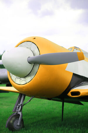 Retro airplane on the background of blue sky and fieldsの写真素材