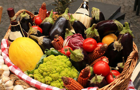 Vegetables and fruits with herbs and wine in a basketの写真素材