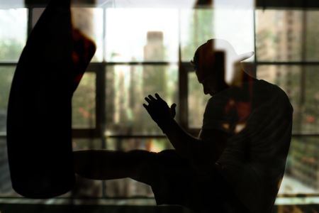 Boxer hits a punching bag against the window, trainingの写真素材