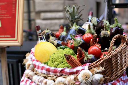 Vegetables and fruits with herbs and wine in a basketの写真素材