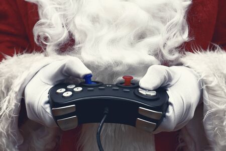 Santa Claus in white gloves holding a joystickの写真素材