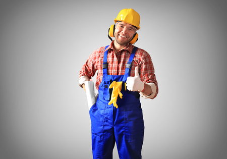 Builder in yellow helmet, protective glasses and working clothesの写真素材