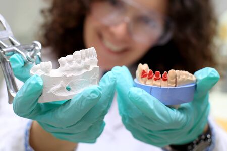 Dental technician checks his work in the lab