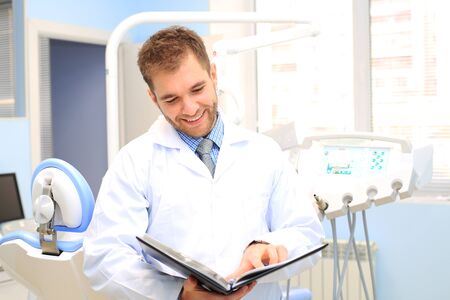 Dentist writes a patient a prescription in medical officeの写真素材