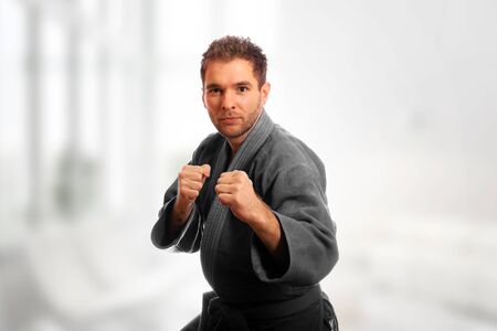 Karate man in a kimono and in a combat stance ready for a fightの写真素材