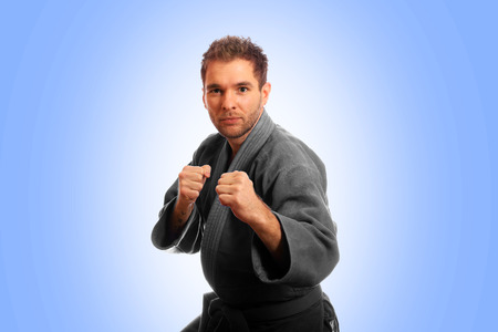 Karate man in a kimono and in a combat stance ready for a fightの写真素材