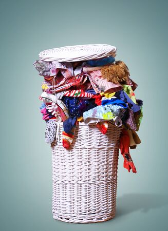 White straw basket full of dirty Laundryの写真素材