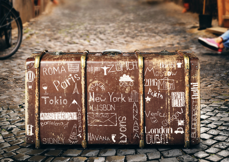 Retro suitcase of a traveler with travel marksの写真素材