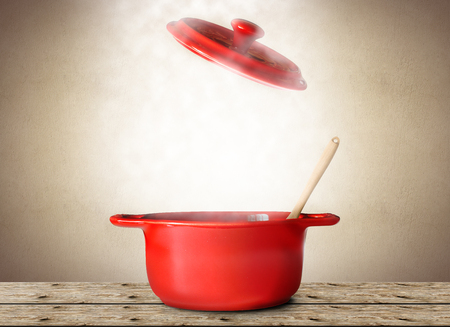 Big red pot for soup with spoon and forkの写真素材