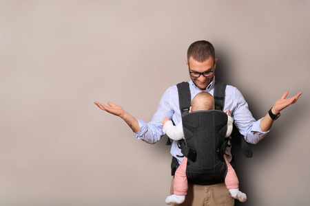 Father holds a baby in a bagの写真素材