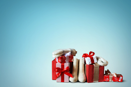 Christmas gifts and white felt boots with wool socksの写真素材