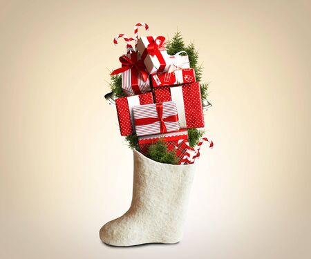 Christmas gifts and white felt boots with wool socksの写真素材