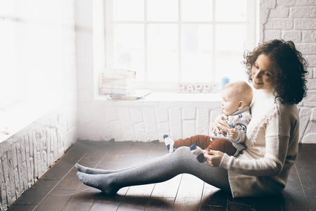 Mother and little child play in homeの写真素材