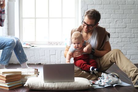 Young happy family relaxing at home on the floorの写真素材
