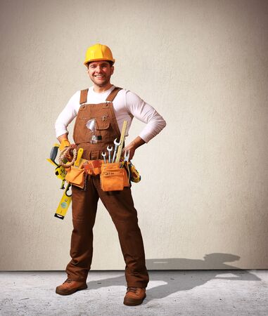 Builder in yellow helmet, protective glasses and working clothesの写真素材