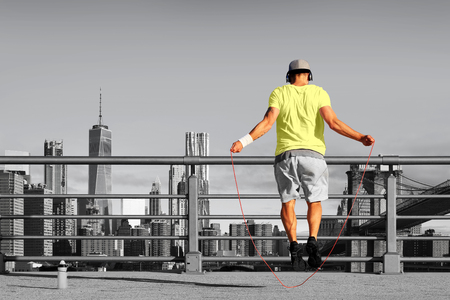 Morning exercises with skipping rope on the background of the cityの写真素材