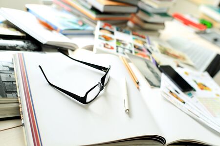 Stack of books on the desktop, and glasses