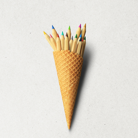 Colored pencils in a waffle Cup from under the ice creamの写真素材