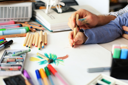 Dad teaches young son to draw pencilの写真素材