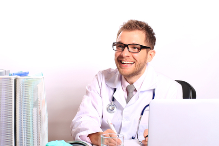 Doctor writes a patient a prescription in medical officeの写真素材