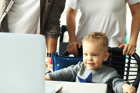 Little boy with his parents sitting at the laptopの写真素材