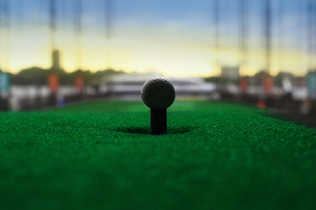 Golf ball set for hitting against city backgroundの写真素材