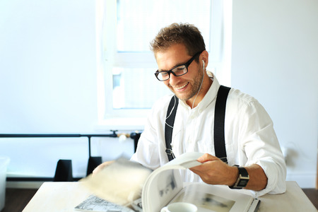 Young man sitting at the table and smilingの写真素材
