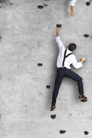 Businessman climbs the wall as a climber, business conceptの写真素材