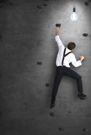 Businessman climbs the wall as a climber, business conceptの写真素材