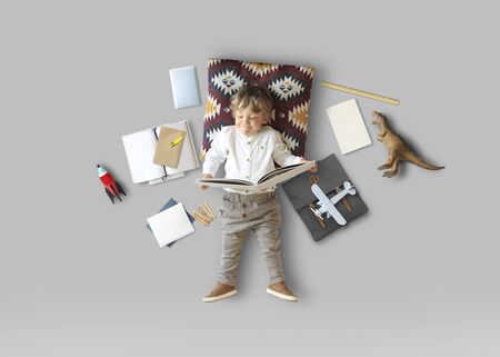 Little boy sits and plays on the floor among his toysの写真素材