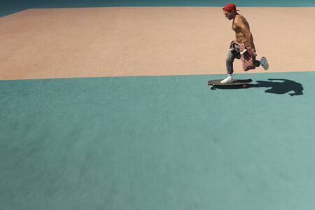 A young man rides a skateboard in a skate park