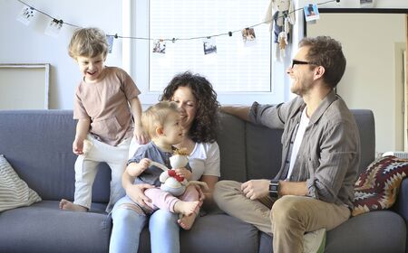 Young beautiful happy family relaxing at homeの写真素材